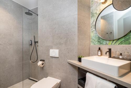 a bathroom with a sink and a mirror at KOOS Hotel&Apartments - City Aparthotel in Munich