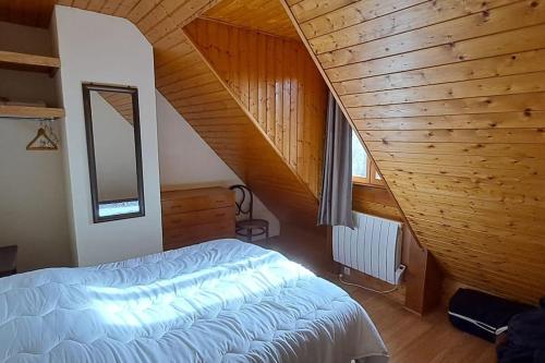 une chambre avec un lit et un plafond en bois dans l'établissement Maison Pyrénées - Poubeau, à Poubeau