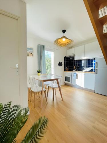 une cuisine et une salle à manger avec une table et des chaises dans l'établissement Bord de mer, maison paisible et rénovée à Penvins, à Sarzeau