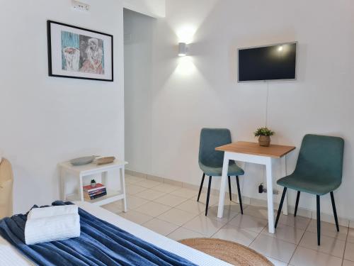 - une chambre avec 2 chaises, une table et une télévision dans l'établissement Minha Casa Sua Casa - Centro Ferragudo, AC, WiFi, à Ferragudo