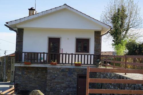 a small white house with a wooden fence at Casa Golden in Bragança