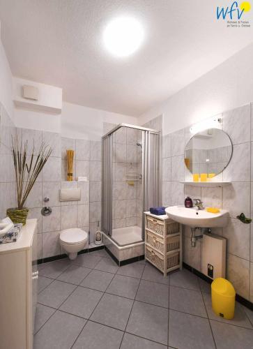 a bathroom with a shower toilet and a sink at Haus Bahnhofstraße 11a Ferienwohnung Kleine Inselliebe in Wangerooge
