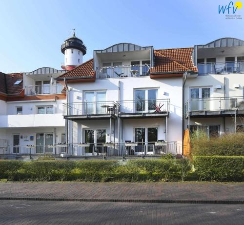 a white building with a light house with a lighthouse at Haus Bahnhofstraße 11a Ferienwohnung Kleine Inselliebe in Wangerooge