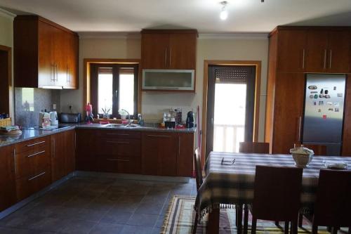 eine Küche mit Holzschränken und einem Tisch mit Stühlen in der Unterkunft Casa Golden in Bragança
