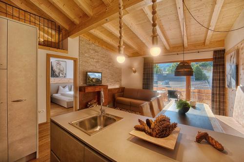 eine Küche mit einem Waschbecken und ein Wohnzimmer in der Unterkunft Residence Alpenrose in St. Johann im Ahrntal