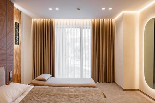 a bedroom with two beds and a large window at Tavel Hotel & SPA in Bukovel