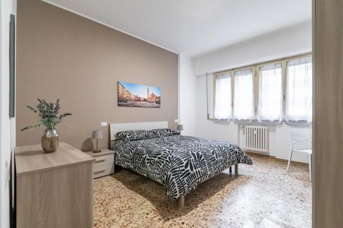 1 dormitorio con 1 cama, escritorio y ventanas en Roomy Apartment Close to Siena Center!, en Siena