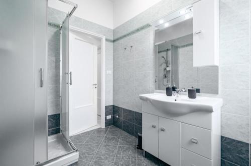 y baño blanco con lavabo y ducha. en Roomy Apartment Close to Siena Center!, en Siena
