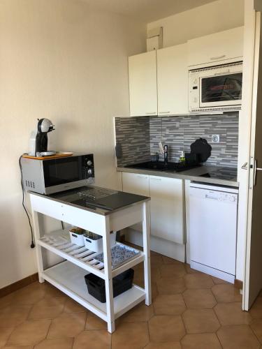 une cuisine avec un four micro-ondes et un comptoir. dans l'établissement Studio cabine climatisé, à Sanary-sur-Mer