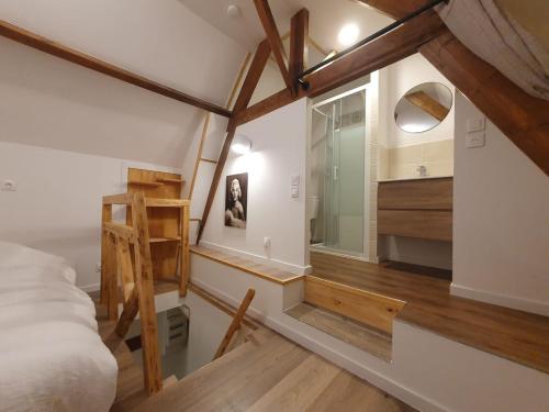 Cette chambre comprend un lit, un lavabo et un miroir. dans l'établissement Logement village calme, à Bersée