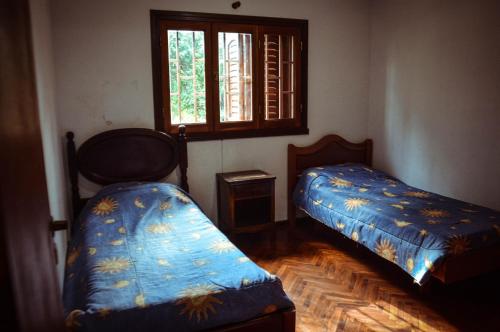 a room with two beds and a window at El patio de Malek in Cosquín