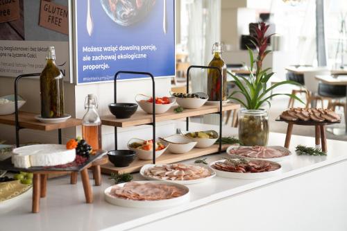 a buffet of food on a table with bottles at Novotel Warszawa Centrum in Warsaw