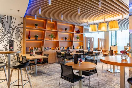 a restaurant with tables and chairs and shelves at Novotel Warszawa Centrum in Warsaw