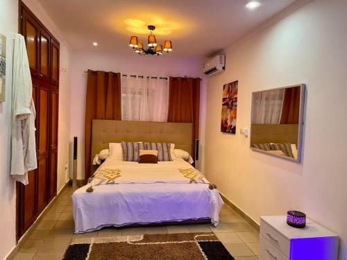- une chambre avec un grand lit dans l'établissement Mini villa cosy et discrete, à Douala