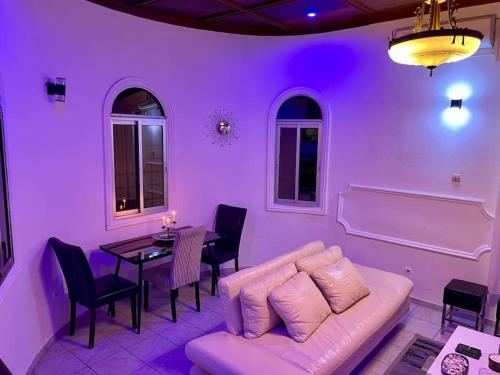 a purple living room with a couch and a table at Mini villa cosy et discrete in Douala