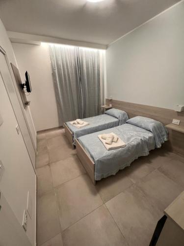 a bedroom with two beds and a window at Porta sul Mare in Tropea