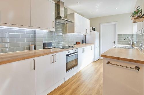 a kitchen with white cabinets and wooden counter tops at Host & Stay - Appleton House in Newark-on-Trent