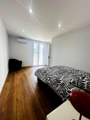 - une chambre avec un lit noir et blanc et du parquet dans l'établissement Grande villa proche de la mer, à Canet