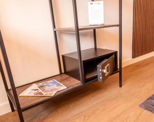 a book shelf with a book and a magazine at Hotel Bom in Burgh Haamstede