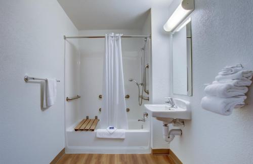 a white bathroom with a shower and a sink at Motel 6-Grants Pass, OR in Grants Pass