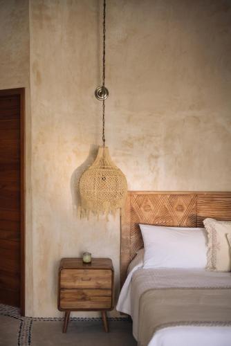 a bedroom with a bed and a chandelier at Casa Las Tortugas Petit Beach Hotel & Spa in Holbox Island