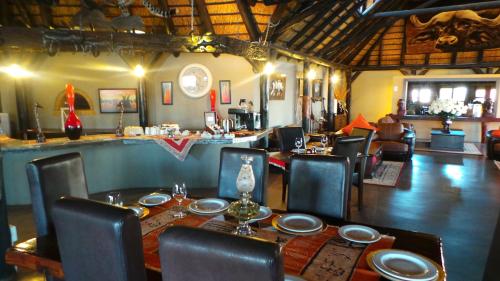 a dining room with a table and chairs and a room with at Lapa Lange Game Lodge in Mariental