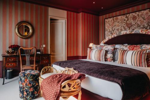 a hotel room with two beds and a chair at Vinha Boutique Hotel - The Leading Hotels of the World in Vila Nova de Gaia