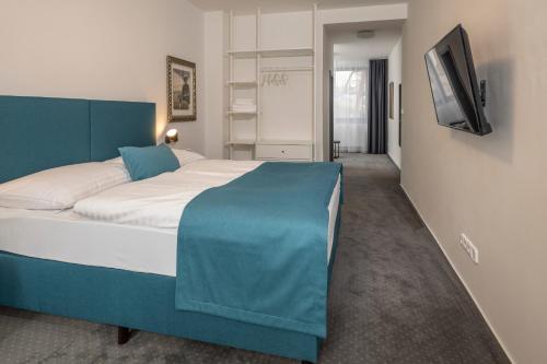 Hotel VP1 في أوسترافا: غرفة نوم بسرير وتلفزيون على جدار