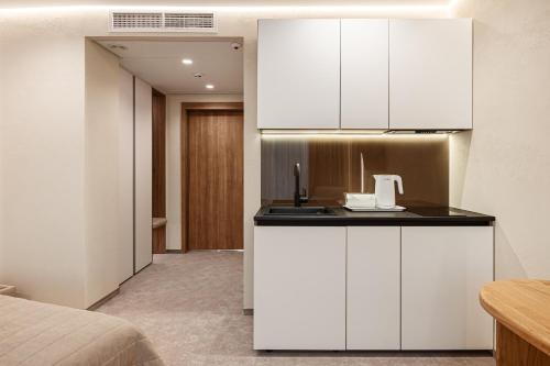 a room with a kitchen with white cabinets at Tavel Hotel & SPA in Bukovel