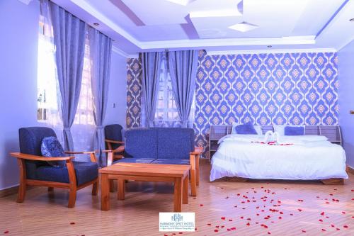 1 Schlafzimmer mit einem Bett, 2 Stühlen und einem Tisch in der Unterkunft Harmony Spot Hotel in Marsabit
