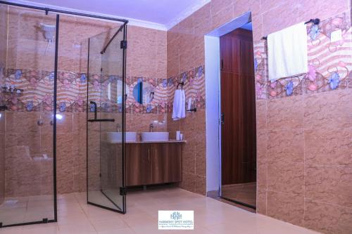 uma casa de banho com um chuveiro e um lavatório. em Harmony Spot Hotel em Marsabit