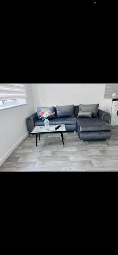 a blue couch in a living room with a table at pro-let one bed apartment Ipswich sleeps up to 4 in Westerfield