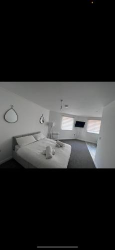 1 dormitorio con 1 cama grande y 2 ventanas en pro-let one bed apartment Ipswich sleeps up to 4 en Westerfield