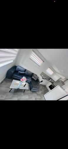 sala de estar con sofá azul y mesa en pro-let one bed apartment Ipswich sleeps up to 4 en Westerfield