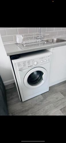 a washing machine with a laundry basket on top of it at pro-let one bed apartment Ipswich sleeps up to 4 in Westerfield