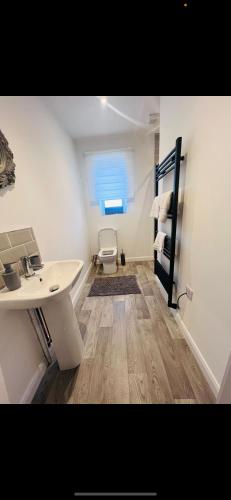a bathroom with a sink and a chair in a room at pro-let one bed apartment Ipswich sleeps up to 4 in Westerfield