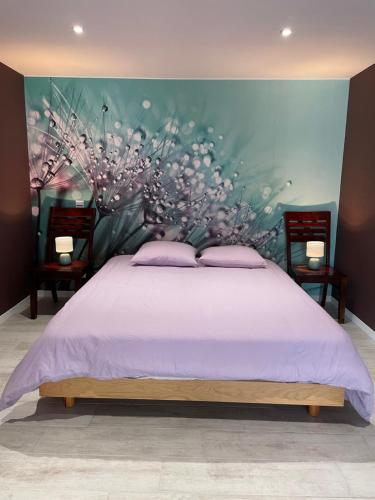sypialnia z łóżkiem z kwiatową ścianą w obiekcie l'Héberge du Lac d'Isachris (Médoc) w mieście Queyrac