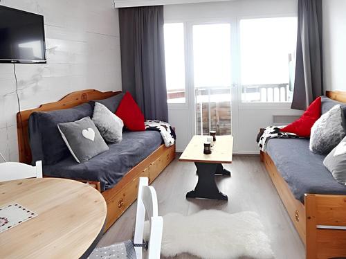 een woonkamer met twee bedden en een tafel bij Appartement charmant à Avoriaz - Vue montagnarde - 26 m² in Avoriaz
