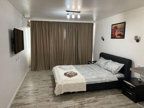 1 dormitorio con 1 cama y TV en Cominyresidence en Popeşti-Leordeni