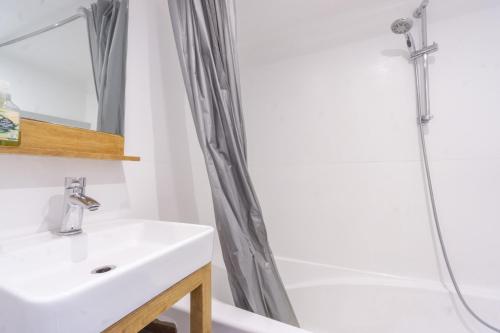 une salle de bain avec un lavabo et une douche dans l'établissement Arc 2000 appartement type chalet, à Bourg-Saint-Maurice