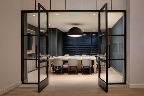 Un comedor con una mesa y sillas blancas. en Sheraton Fort Worth Downtown Hotel, en Fort Worth