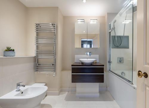 a bathroom with a sink and a toilet and a shower at Beautiful 2-Bedroom Apartment in Mayfair in London