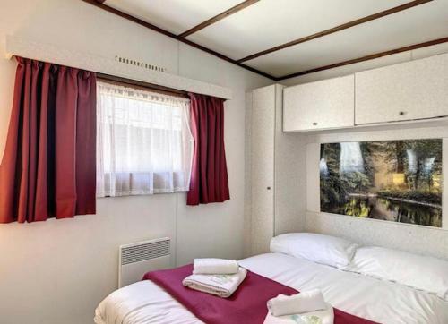 a small room with two beds and a window at Le chalet de Blonville in Blonville-sur-Mer