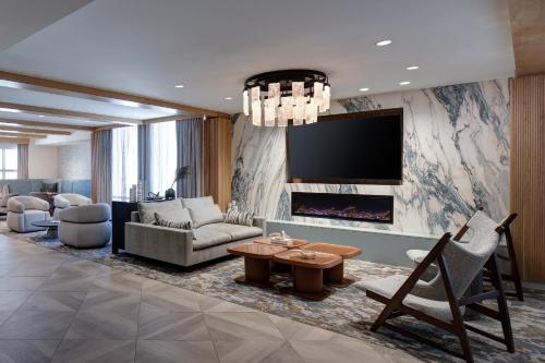 a living room with a couch and a fireplace at Sheraton Fort Worth Downtown Hotel in Fort Worth