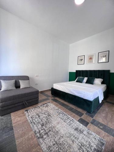 a bedroom with a bed and a couch at Cactus Apartments in Durrës