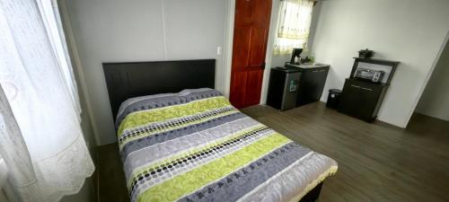 ein Schlafzimmer mit einem Bett mit einer Decke darauf in der Unterkunft Villa Congos in Delicias