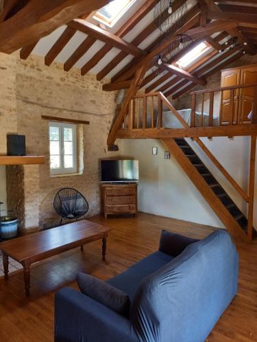 a living room with a blue couch and a wooden table at Gîte le Pech in Sainte-Foy-de-Longas