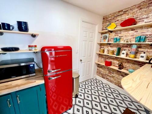 a red refrigerator in a kitchen with a brick wall at Walk everywhere! Stylish apartment for up to 5 in Albany