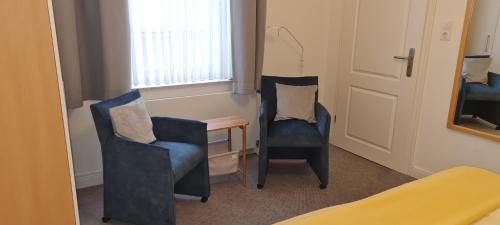 ein Zimmer mit zwei Stühlen und einem Tisch und einem Fenster in der Unterkunft Ferienhaus Pauls Ferienhaus Pauls, Whg 07 in Norderney