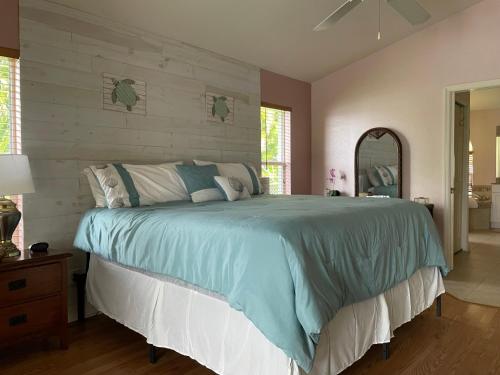 ein Schlafzimmer mit einem großen Bett und einem Spiegel in der Unterkunft Relax with nature in our Waterfront 4 bedroom -HEATED POOL HOME-KING BED in Cape Coral